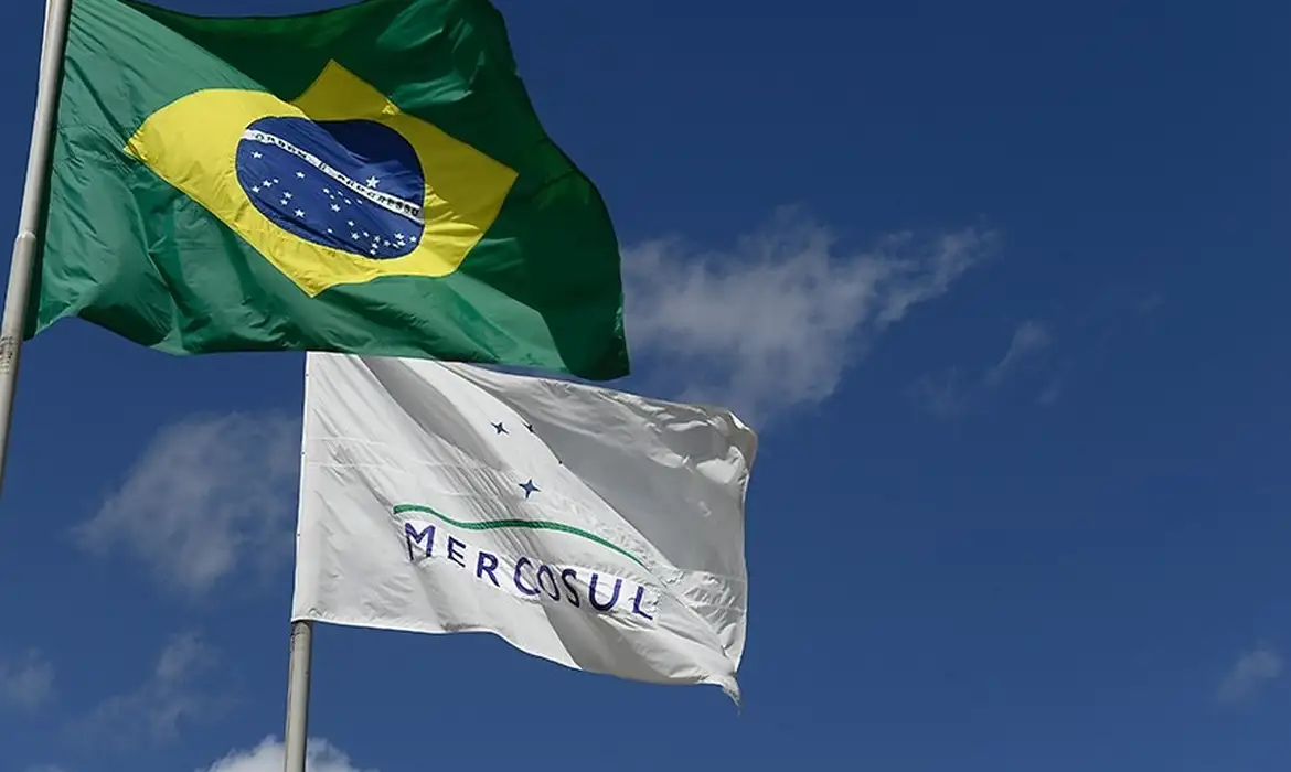 Representação do acordo Mercosul União Europeia com bandeiras dos blocos durante anúncio do tratado comercial